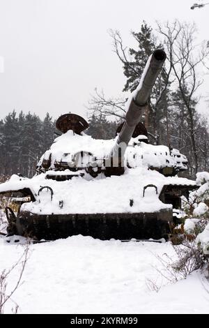 Russischer Kampfpanzer im Schnee, der am Straßenrand der Autobahn während der Feindseligkeiten bei der russischen Invasion der Ukraine 2022 zerstört wurde. Krieg in der Ukraine Stockfoto