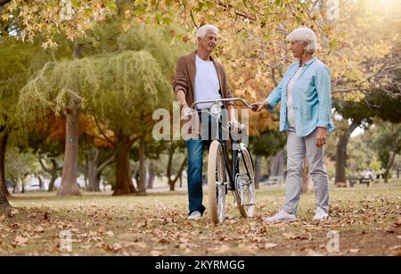 Seniorenpaar, Bindungen oder Fahrradunterricht in der Natur auf dem Land, in öffentlichen Parks oder im Garten bei Liebesdate, Erlebnis oder Gelegenheit. Altersruhestand Stockfoto