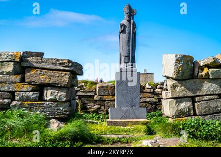 BALLYCASTLE, COUNTY MAYO, REPUBLIK IRLAND - JULI 15 2022 : die Statue des heiligen Patrick steht am Downpatrick Head nicht weit vom Meeresstapel entfernt. Stockfoto