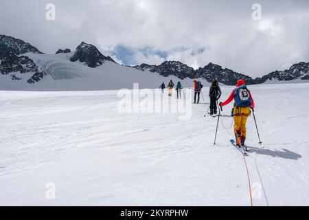 Tour in großer Höhe, Skitouristen, die an einem Seil über den Alpeiner Ferner Gletscher laufen, Winter in den Bergen, Neustift im Stubai-Tal, Tirol, Österreich, EU Stockfoto