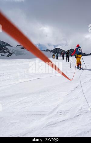 Tour in großer Höhe, Skitouristen, die an einem Seil über den Alpeiner Ferner Gletscher laufen, Winter in den Bergen, Neustift im Stubai-Tal, Tirol, Österreich, EU Stockfoto