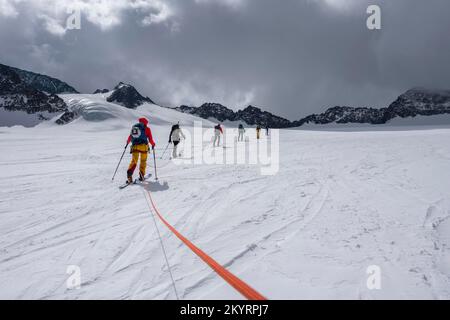 Tour in großer Höhe, Skitouristen, die an einem Seil über den Alpeiner Ferner Gletscher laufen, Winter in den Bergen, Neustift im Stubai-Tal, Tirol, Österreich, EU Stockfoto