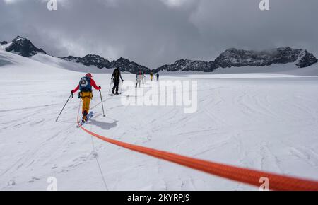 Tour in großer Höhe, Skitouristen, die an einem Seil über den Alpeiner Ferner Gletscher laufen, Winter in den Bergen, Neustift im Stubai-Tal, Tirol, Österreich, EU Stockfoto