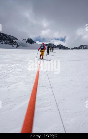 Tour in großer Höhe, Skitouristen, die an einem Seil über den Alpeiner Ferner Gletscher laufen, Winter in den Bergen, Neustift im Stubai-Tal, Tirol, Österreich, EU Stockfoto