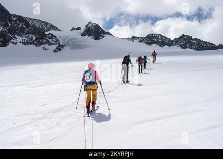 Tour in großer Höhe, Skitouristen, die an einem Seil über den Alpeiner Ferner Gletscher laufen, Winter in den Bergen, Neustift im Stubai-Tal, Tirol, Österreich, EU Stockfoto