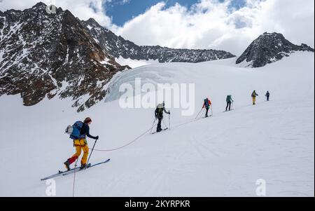 Tour in großer Höhe, Skitouristen, die an einem Seil über den Alpeiner Ferner Gletscher laufen, Winter in den Bergen, Neustift im Stubai-Tal, Tirol, Österreich, EU Stockfoto