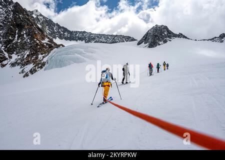 Tour in großer Höhe, Skitouristen, die an einem Seil über den Alpeiner Ferner Gletscher laufen, Winter in den Bergen, Neustift im Stubai-Tal, Tirol, Österreich, EU Stockfoto