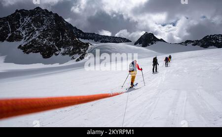 Tour in großer Höhe, Skitouristen, die an einem Seil über den Alpeiner Ferner Gletscher laufen, Winter in den Bergen, Neustift im Stubai-Tal, Tirol, Österreich, EU Stockfoto