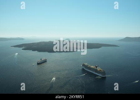 Santorin, Griechenland - 16. September 2022 : Panoramablick auf zwei Kreuzfahrtschiffe neben dem Vulkan und einen wunderschönen blauen Himmel in Santorini Griechenland Stockfoto