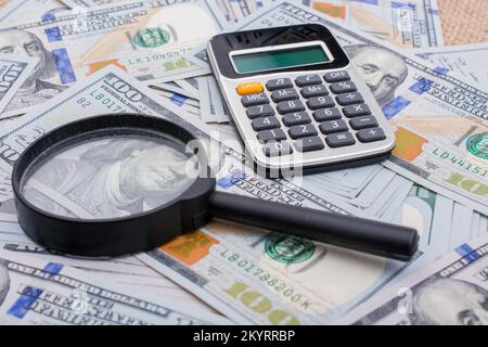 Lupe wird über die Banknote Bündel von US-Dollar gehalten. Stockfoto