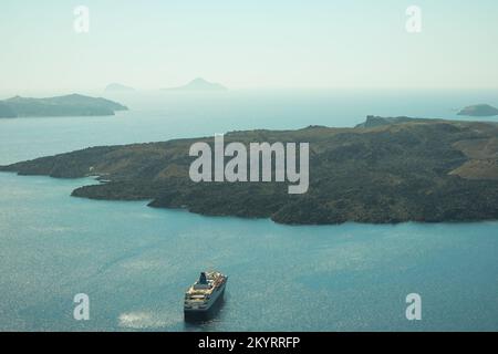 Santorin, Griechenland - 16. September 2022 : Blick auf einen Kreuzfahrtschiff neben dem berühmten Vulkan von Santorin Stockfoto