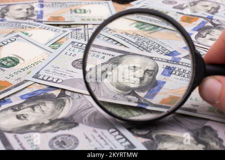 Lupe wird über die Banknote Bündel von US-Dollar gehalten. Stockfoto