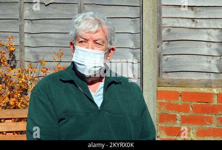 Ältere oder ältere Person trägt eine Maske, um zu verhindern, dass sich ein Virus ähnlich wie Covid ansteckt oder weitergibt. Stockfoto