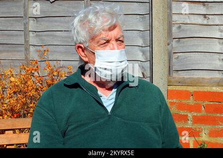 Ältere oder ältere Person trägt eine Maske, um zu verhindern, dass sich ein Virus ähnlich wie Covid ansteckt oder weitergibt. Stockfoto