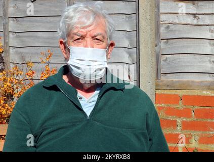 Ältere oder ältere Person trägt eine Maske, um zu verhindern, dass sich ein Virus ähnlich wie Covid ansteckt oder weitergibt. Stockfoto