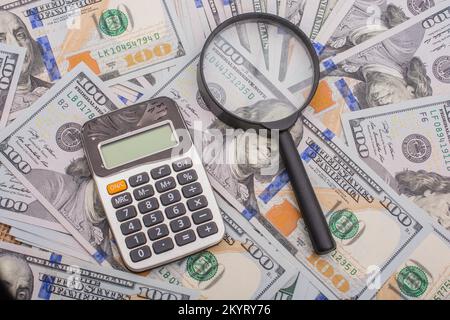 Lupe wird über die Banknote Bündel von US-Dollar gehalten. Stockfoto