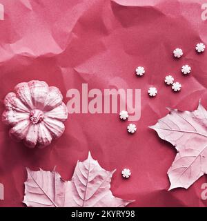 Herbst-Magenta-Hintergrund mit bemalten Ahornblättern, Kürbissen und Reihen von Zuckerstreuseln. Lebendige monochromatische Kulisse, Geschichten für Social Media. Stockfoto