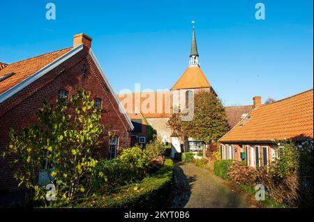 Protestantische Kirche im alten historischen Zentrum von Rysum, Warfendorf in der Gemeinde Krummhörn, Bezirk Aurich, Ostfriesien, Niedersachsen Stockfoto