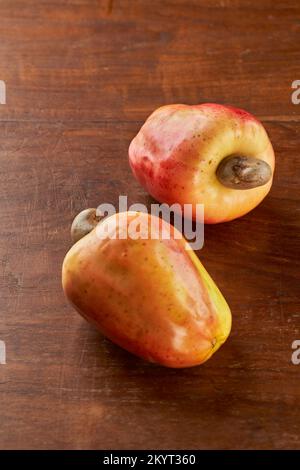 Zwei Kaschu-Nüsse auf einem Holztisch, mit Fokus auf dem hinteren Stockfoto