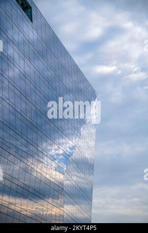Modernes Glasgebäude mit bewölktem Himmel auf den Fenstern in Austin Texas. Blick vom Butler Metro Park auf einen Wolkenkratzer mit glänzendem Äußeren Stockfoto