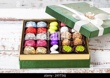 Verpackte Geschenkschokolade. Eine Packung gemischter Schokolade auf Holzhintergrund. Schließen Stockfoto