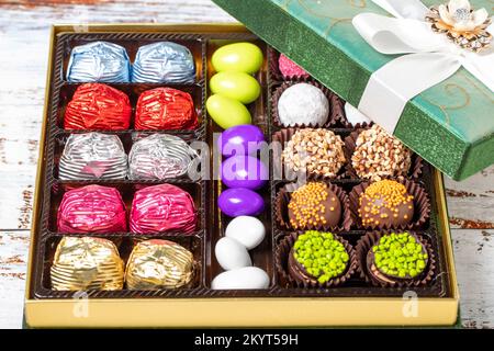 Verpackte Geschenkschokolade. Eine Packung gemischter Schokolade auf Holzhintergrund. Schließen Stockfoto