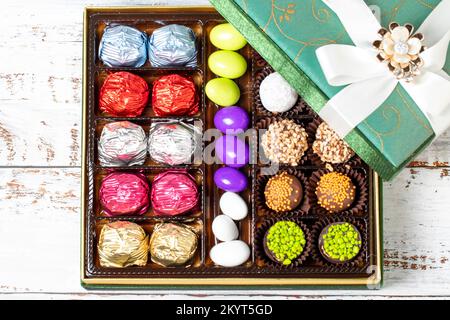 Verpackte Geschenkschokolade. Eine Packung gemischter Schokolade auf Holzhintergrund. Draufsicht Stockfoto