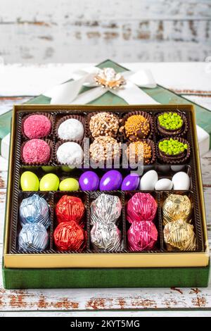 Verpackte Geschenkschokolade. Eine Packung gemischter Schokolade auf Holzhintergrund. Schließen Stockfoto