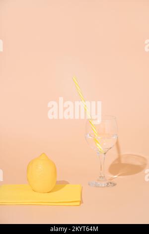 Sauberes Wasser in Glas und zerbrochen. Zitrone auf Serviette. Minimalistisches Design Stockfoto
