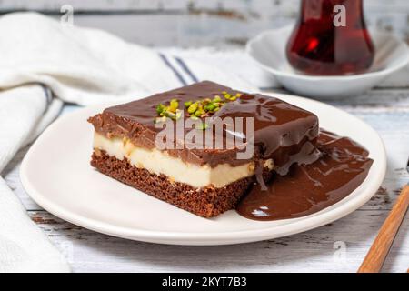 Schokoladenkuchenstück. Schokoladen- und Cremetorte auf Holzboden. Schließen Stockfoto