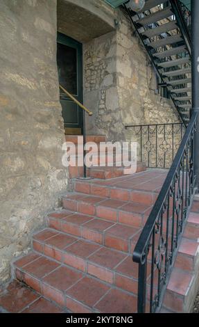 Treppen im Freien am Eingang eines Gebäudes im San Antonio River Walk in Texas. Außenansicht eines alten Gebäudes entlang des Kanals mit Steinwänden und Stand Stockfoto