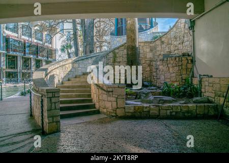 Blick unter einer Brücke auf eine Außentreppe im San Antonio River Walk Texas. Das reflektierende Kanalwasser entlang von Gebäuden ist auch in der B zu sehen Stockfoto