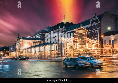 Helsinki, Finnland. Leuchtender rot-orangefarbener Sternenhimmel über der alten Markthalle Vanha Kauppahalli im Stadtzentrum bei Beleuchtung bei Abend- oder Nachtbeleuchtung Stockfoto