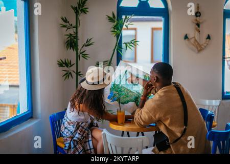 Zwei multiethnische Freunde suchen auf der Karte nach einem nächsten Ziel Stockfoto