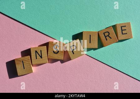 Inspire, Wort in hölzernen Buchstaben isoliert auf Hintergrund Stockfoto