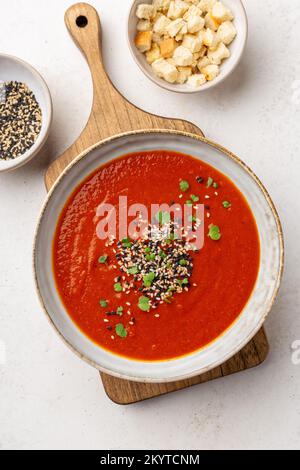 Cremige, warme Tomatensuppe serviert mit Sesamsamen und Mikro-Grüns, Shot über Kopf Stockfoto