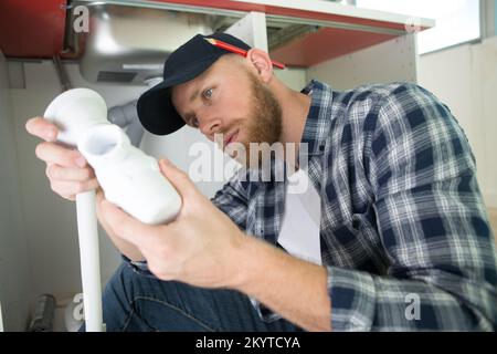 Klempner unter dem Waschbecken in der Küche Stockfoto