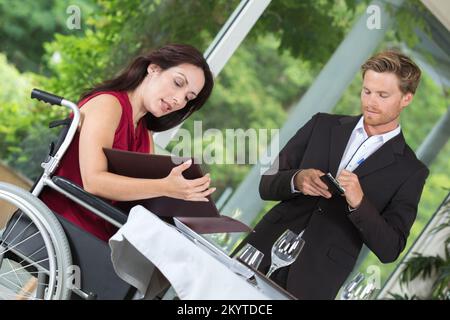 Eine Kundin im Restaurant für Behinderte, die ihr Essen bestellt Stockfoto