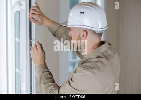 Mann mit einem Schraubendreher auf die Scheibe Stockfoto