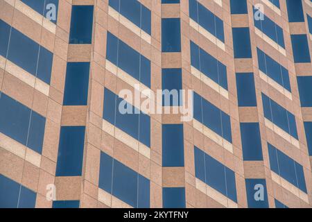 Austin, Texas: Fassade des Gebäudes mit brauner Marmorverkleidung und getönten Panoramafenstern. Nahaufnahme einer Gebäudewand mit hohen Fenstern. Stockfoto