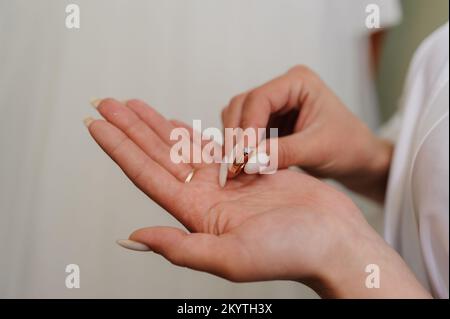 Goldring mit einem Diamanten an der Hand der Braut. Ring mit einem Stein an der Hand einer Frau. Stockfoto