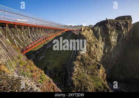 Die neue Brücke und die alte Treppe auf Tintagel Island, Cornwall, England Stockfoto