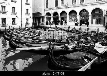 Gondeln liegen in einem Halbkreis an einem Dock in Venedig, Italien. Foto in Schwarzweiß. Ein Kunstfoto Stockfoto