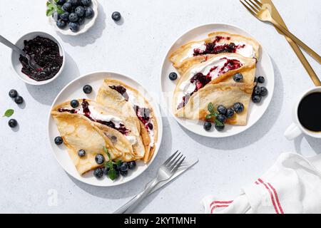 Crepes mit Blaubeermarmelade, Ricotta-Käse und frischen Beeren. Pfannkuchen zum Frühstück. Draufsicht Stockfoto
