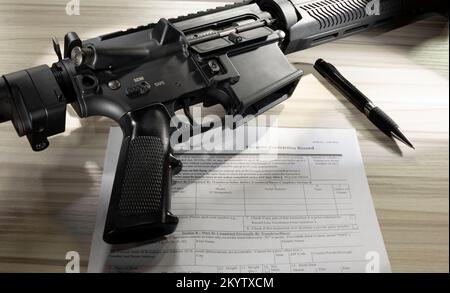 Allgemein zugängliches Formular zur Hintergrundüberprüfung mit AR-15 und Stift in der Nähe Stockfoto