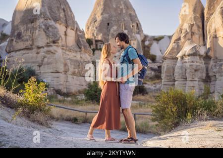 Glückliches Paar Touristen vor dem Hintergrund einzigartiger geologischer Formationen im Love Valley in Kappadokien, einem beliebten Reiseziel in der Türkei Stockfoto