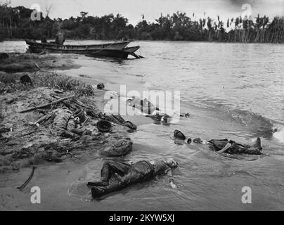 Oldtimer-Foto um den 1943. März von toten japanischen Soldaten neben ihrem zerstörten Landungsschiff an einem Strand in Buna, Neuguinea, nach einem Angriff der US- und australischen Streitkräfte. Stockfoto