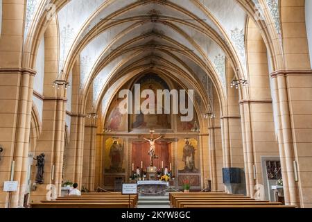 Das zentrale Schiff in der berühmten St. Gangolf's Church, eine römisch-katholische Kirche in Trier. Am Ende des Chors befindet sich ein Fresko, geschaffen von... Stockfoto