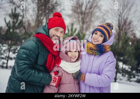 Foto eines bezaubernden, fröhlichen Ehemanns, einer kleinen Ehefrau, die eine Windjacke trägt und die Zeit vor dem Stadtpark gemeinsam genießt Stockfoto