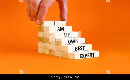 Ich bin mein eigenes bestes Expertensymbol. Konzeptworte Ich bin mein eigener bester Experte für Holzblöcke auf einem schönen orangen Tisch mit orangefarbenem Hintergrund. Geschäftsmann Hand Stockfoto